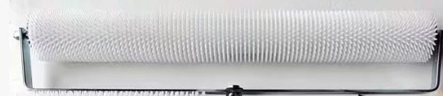 A long white nylon spike roller on its stirrup frame